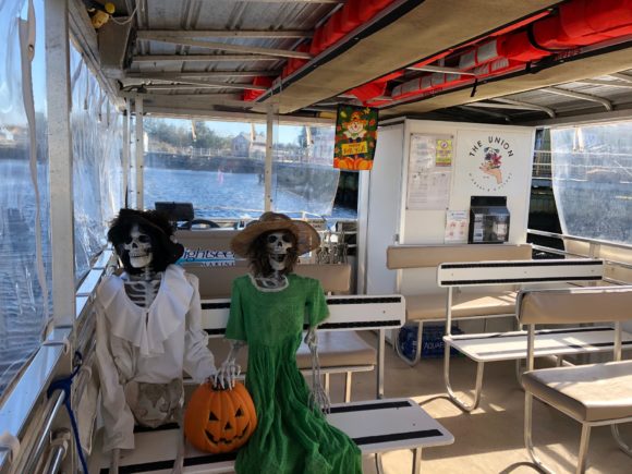Two dressed skeletons sit on the Pohatcong II for a Halloween boat ride with the Tuckerton Seaport, it's one of the best New Jersey Halloween activities.